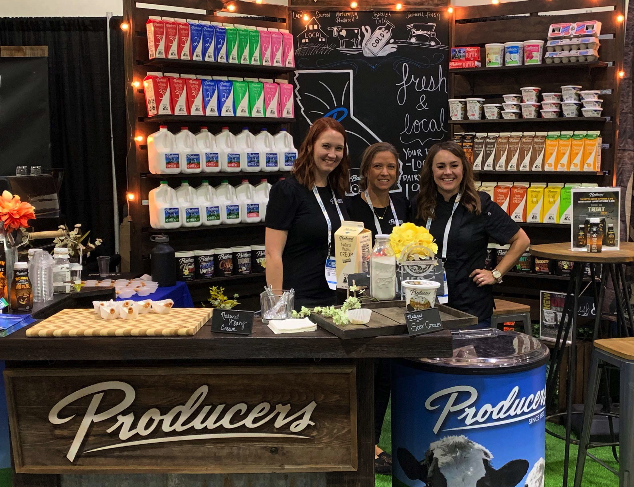 Producers Team Members and Chef Ambassador at the California Food Show standing at their booth.