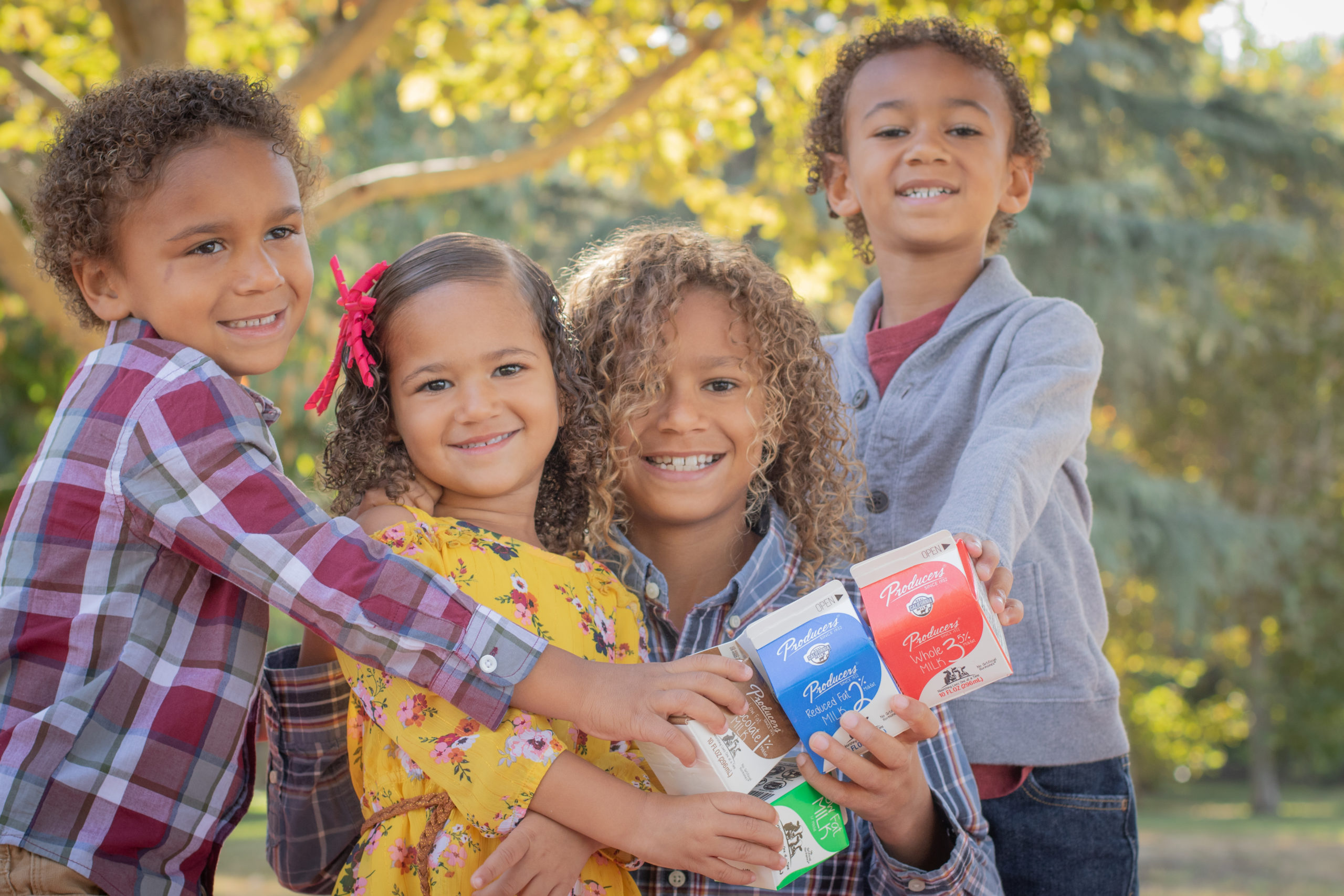 1Y8A6796 4 kids holding producers milk in the park.