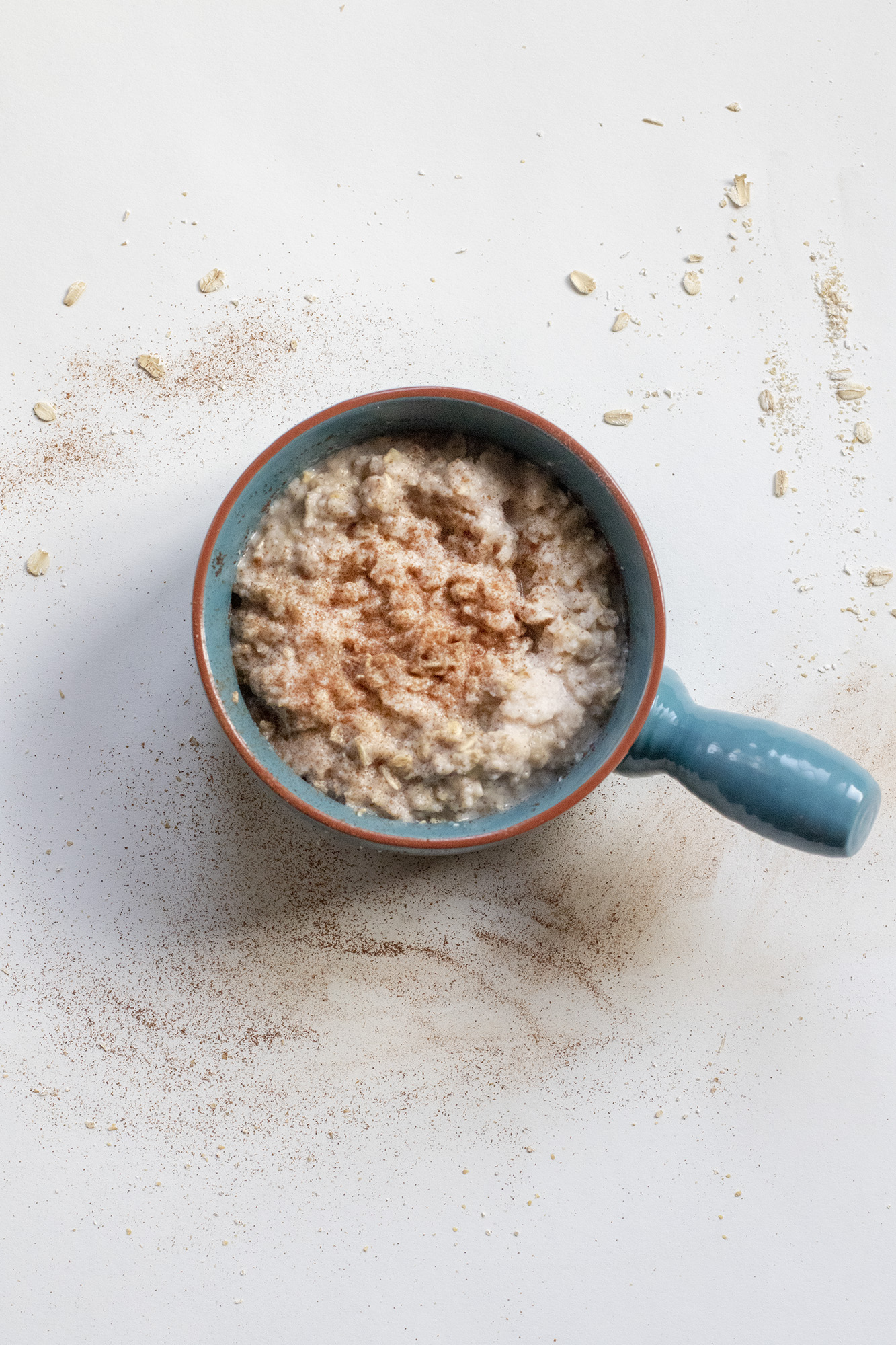 Banana egg white oatmeal in a blue bowl on a white background.